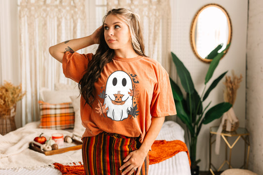 Woman wearing oversized orange pumpkin ghost tee, Halloween streetwear fall outfit